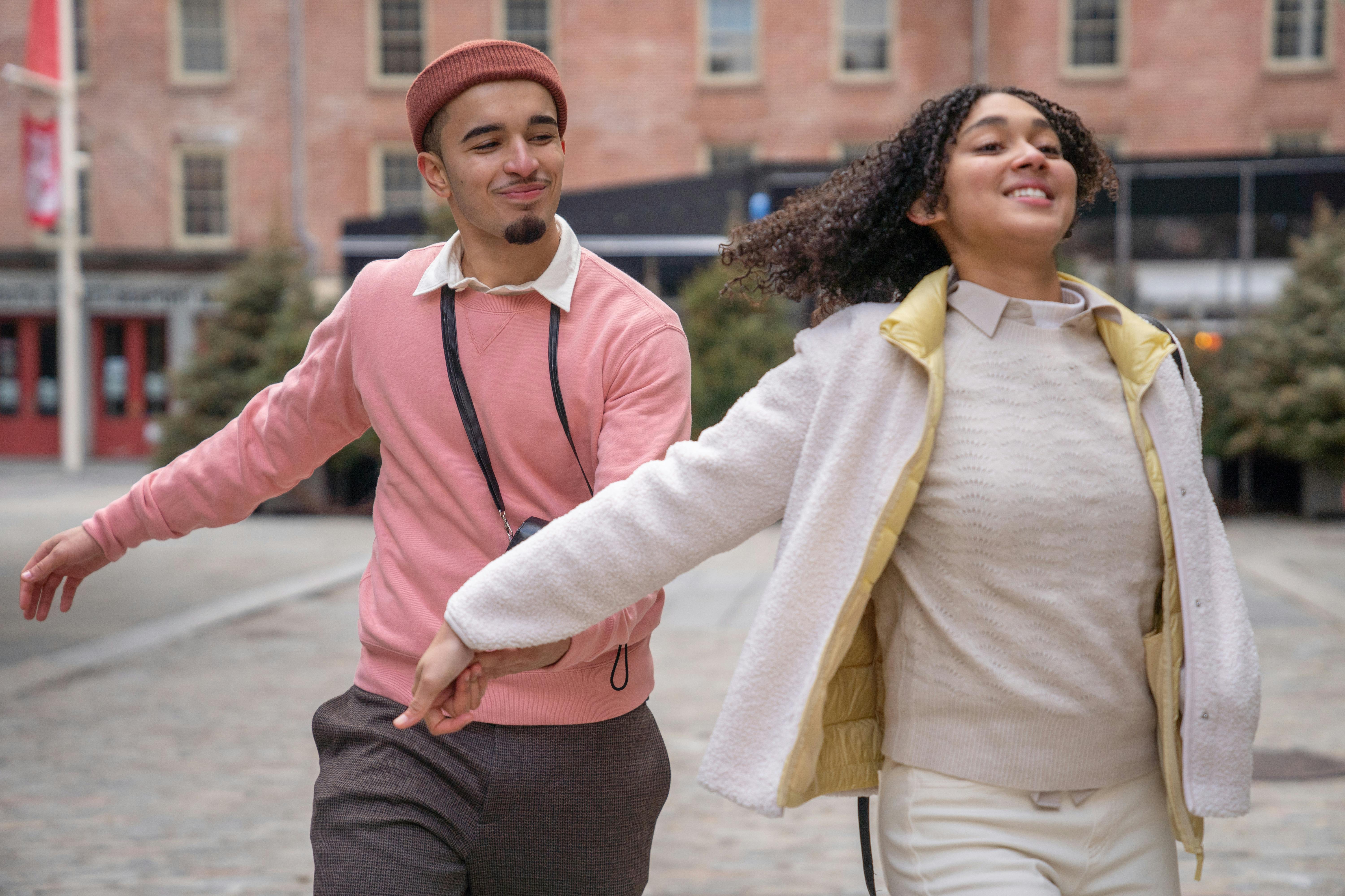 couple holding hands and running in street