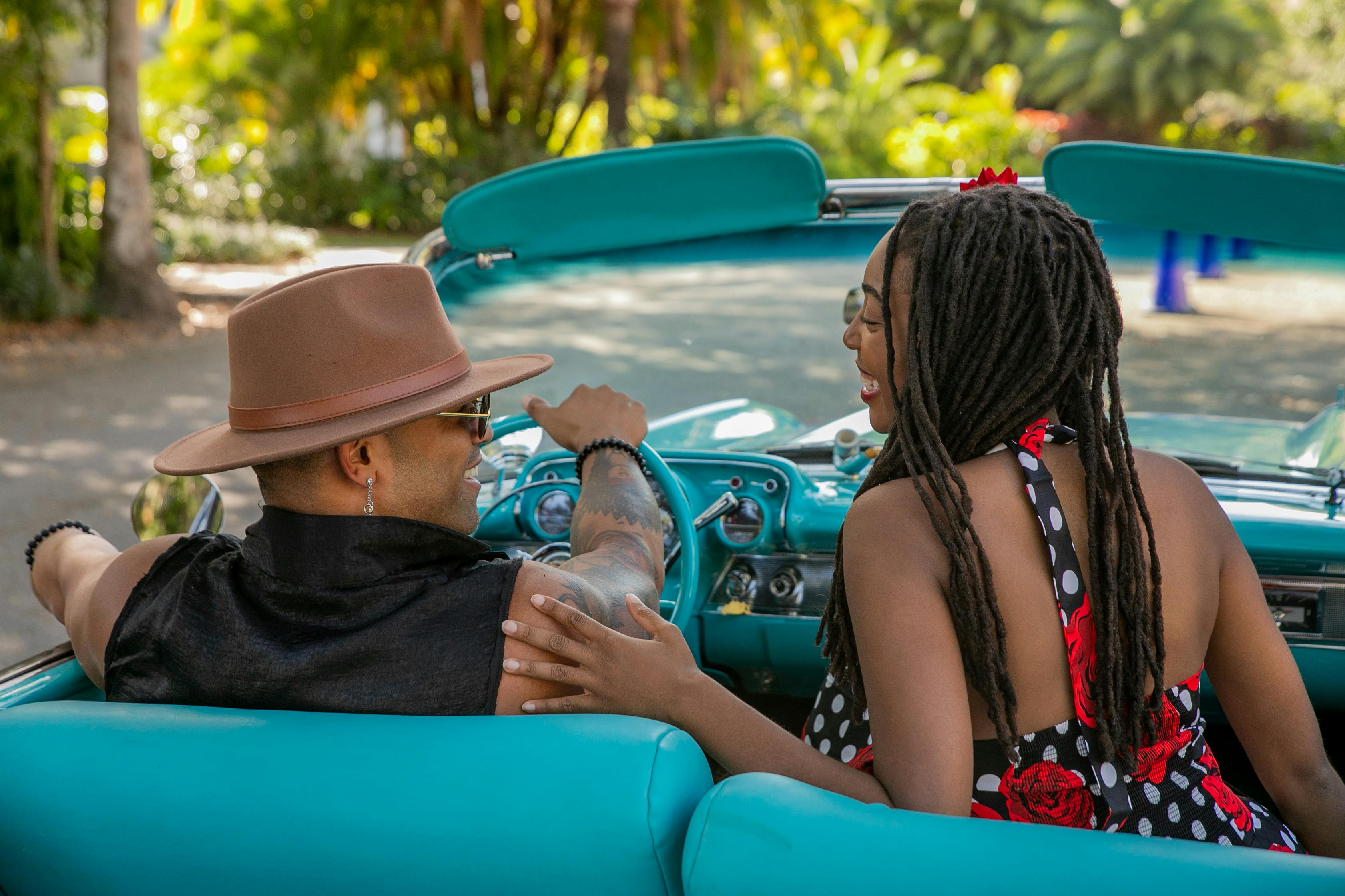 couple driving in blue convertible car