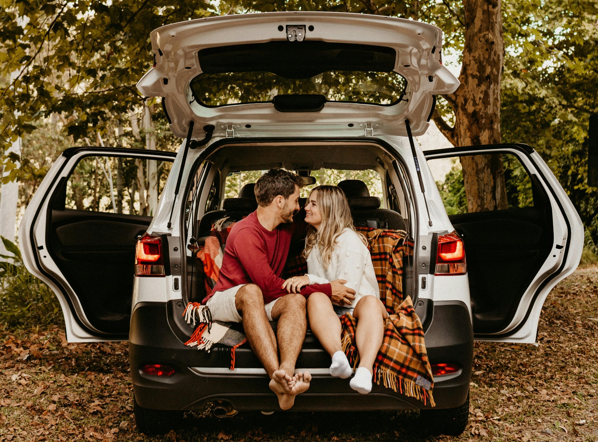 couple in backseat of car with blanket