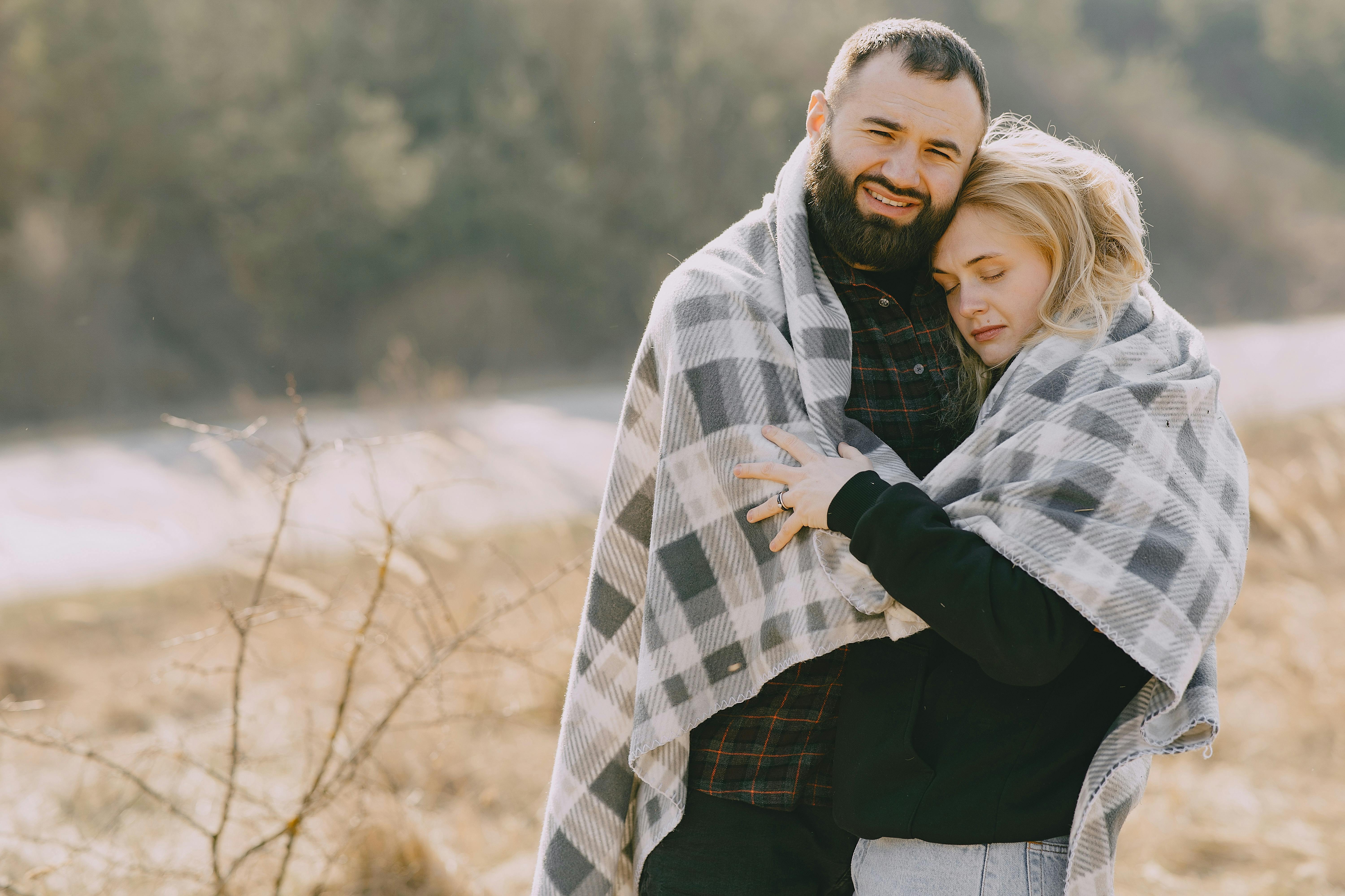 man and woman hugging with blanket
