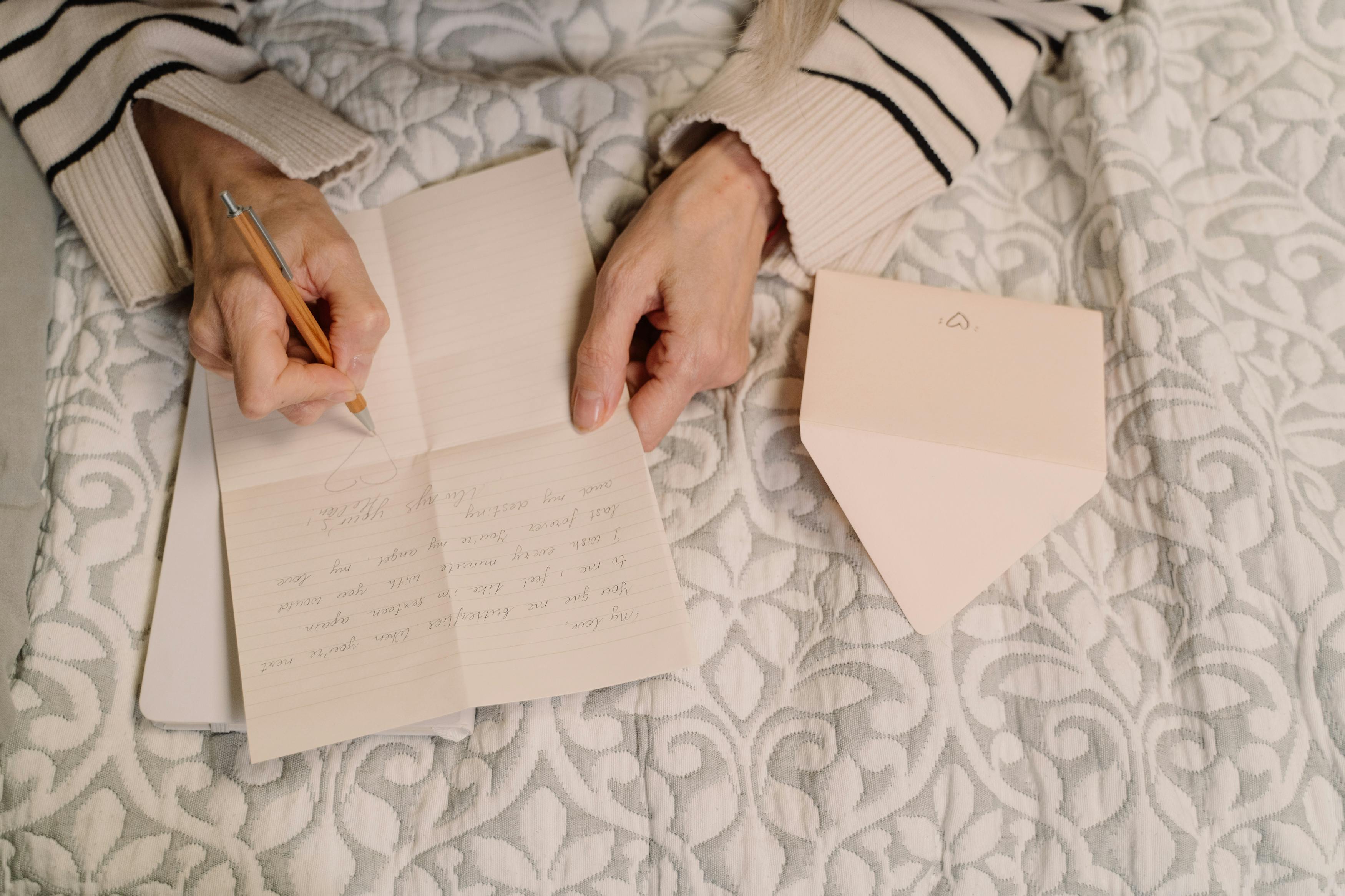 woman writing letter on bed