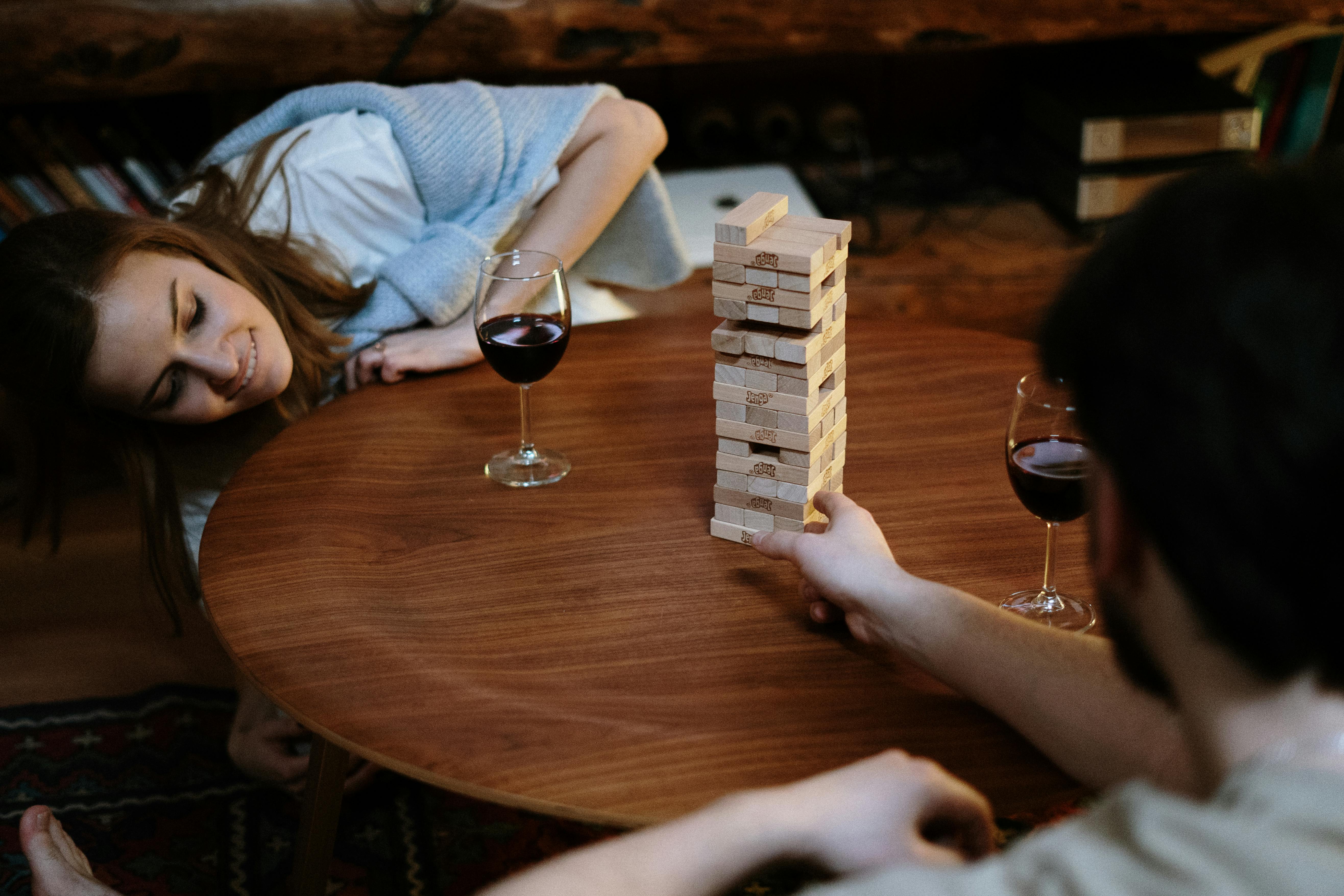 man and woman play jenga on table