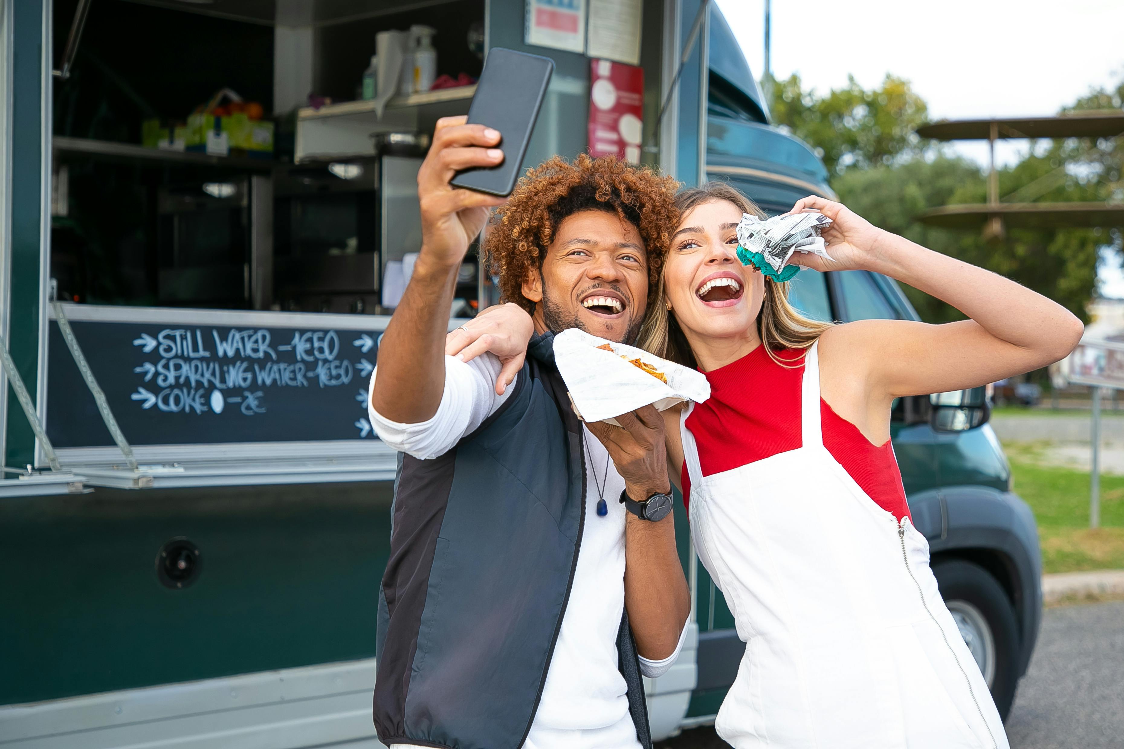 man and woman eating at food truck