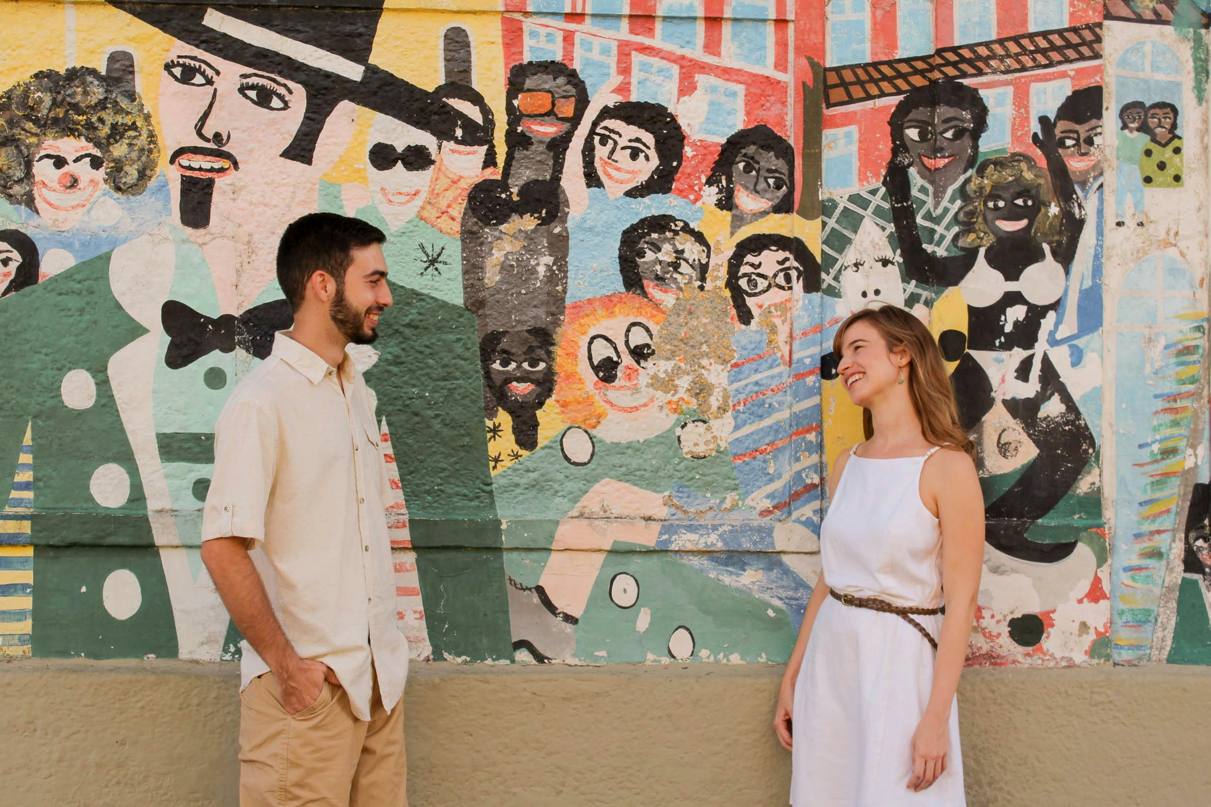 man and woman standing in front of art wall