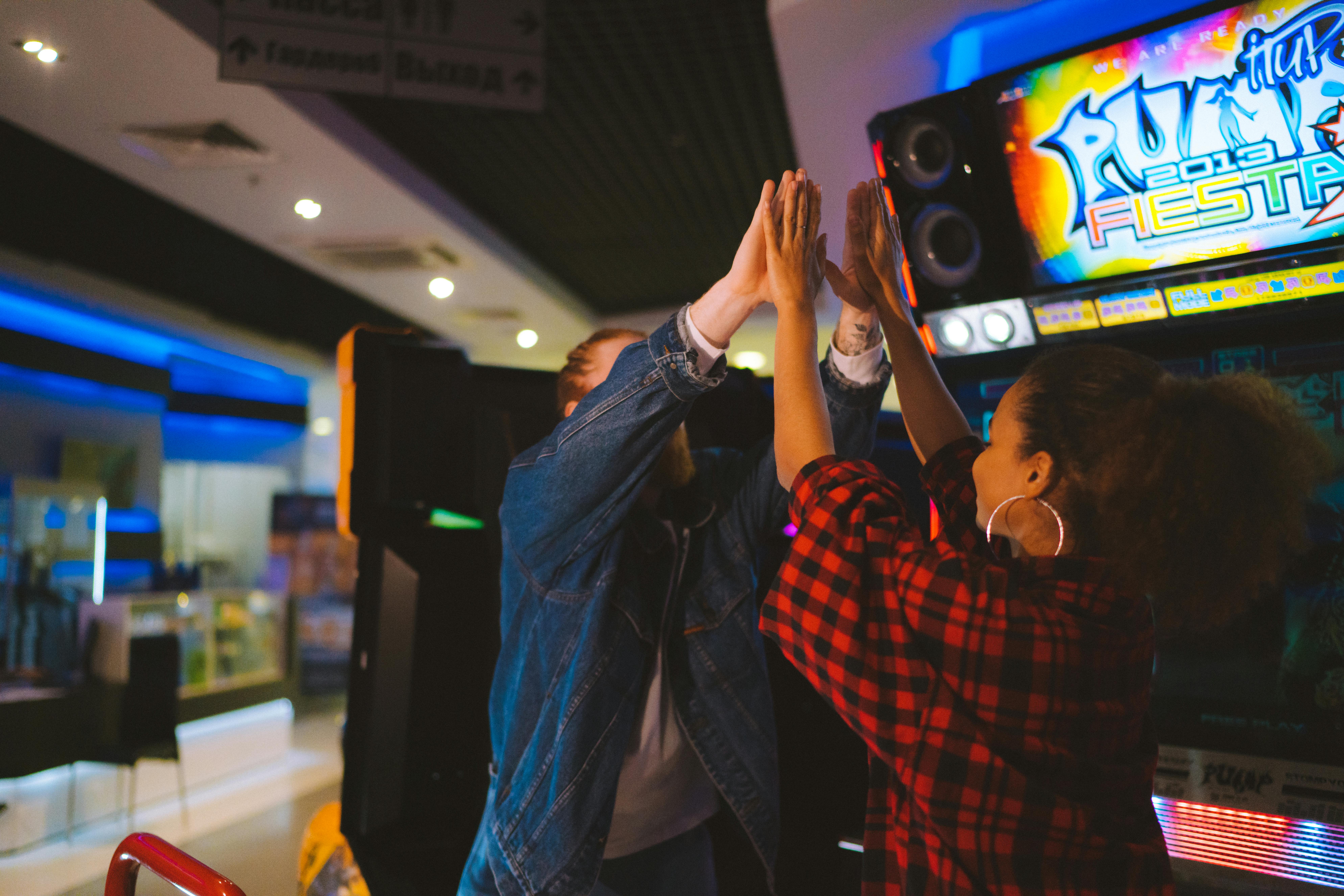 two people high five at the arcade