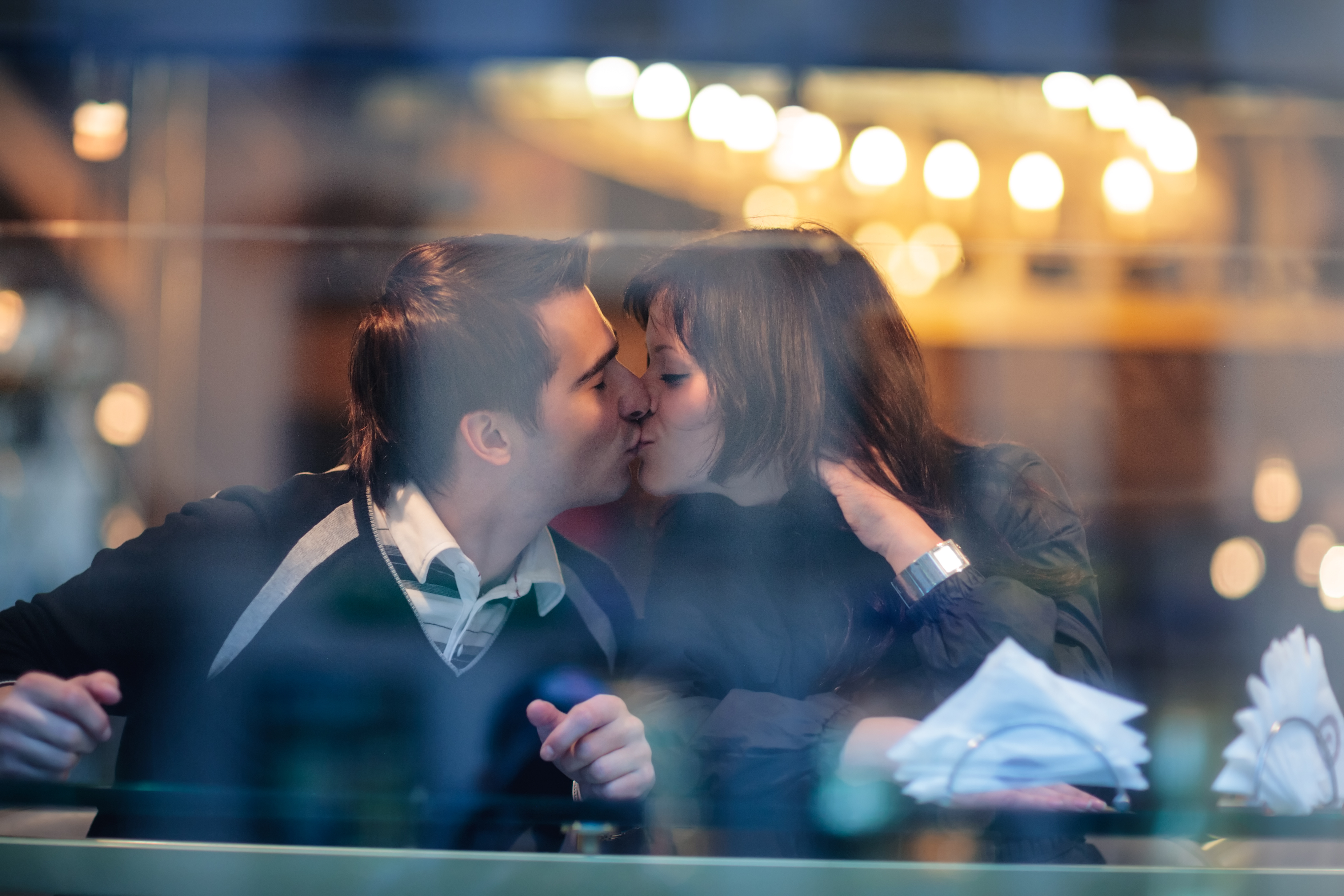 couple kissing at a restaurant 